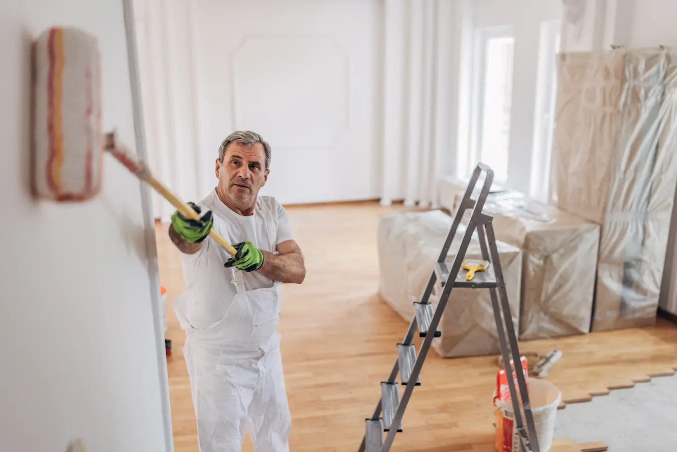 Rulo fırça ile iç cephe duvar boyası yapan usta